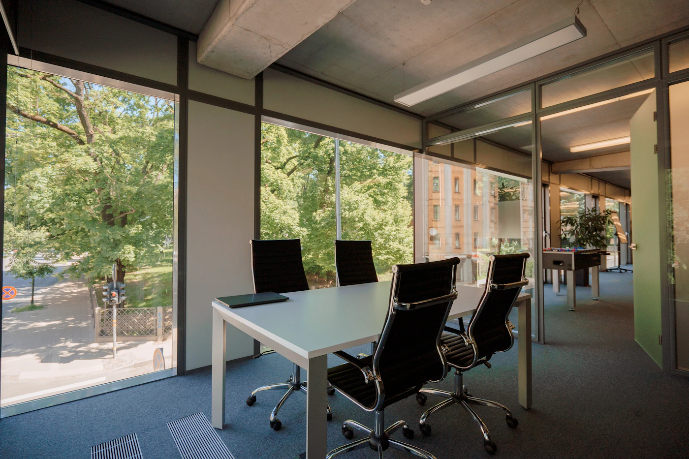 A meeting room in a modern office with a full-height window along one wall