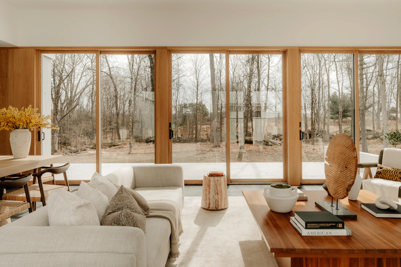 Full-height sliding glass doors opening a living room onto the trees